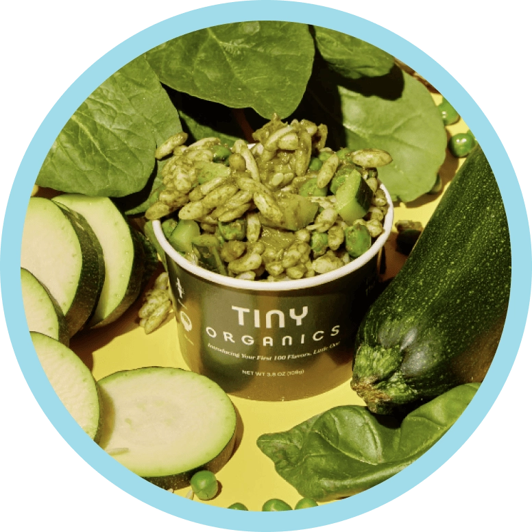 A Tiny cup surrounded by fresh zucchini and spinach